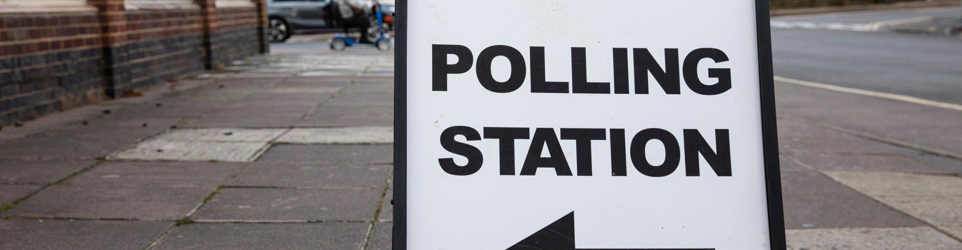 Polling station sign on ground